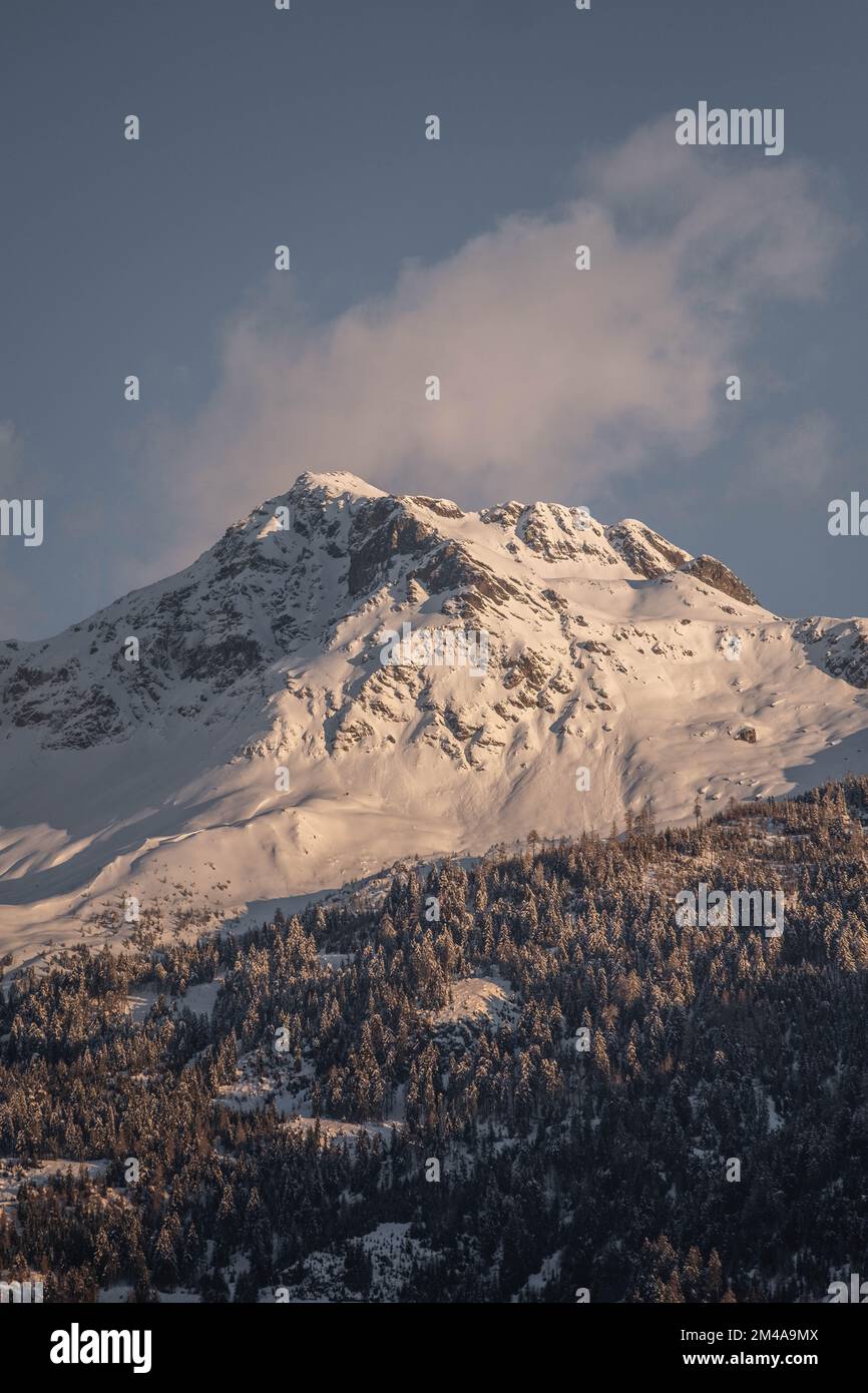 A vertical shot of the Alps covered in snow on a sunny day with a ...