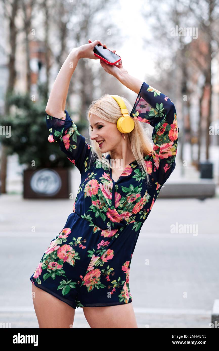 Happy blonde woman dancing in the street Stock Photo - Alamy