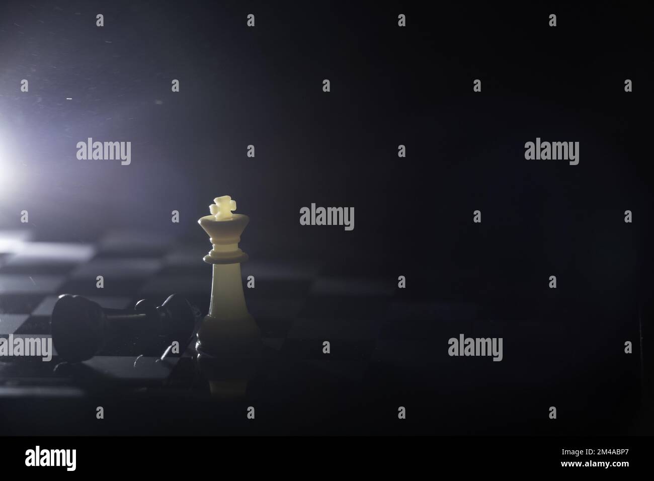 chess pieces on a chessboard in a dark room illuminated by a lantern ...