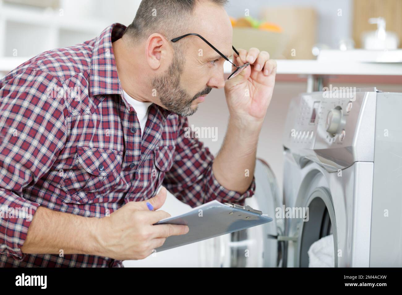 shocked upset man looking at washing machine Stock Photo Alamy