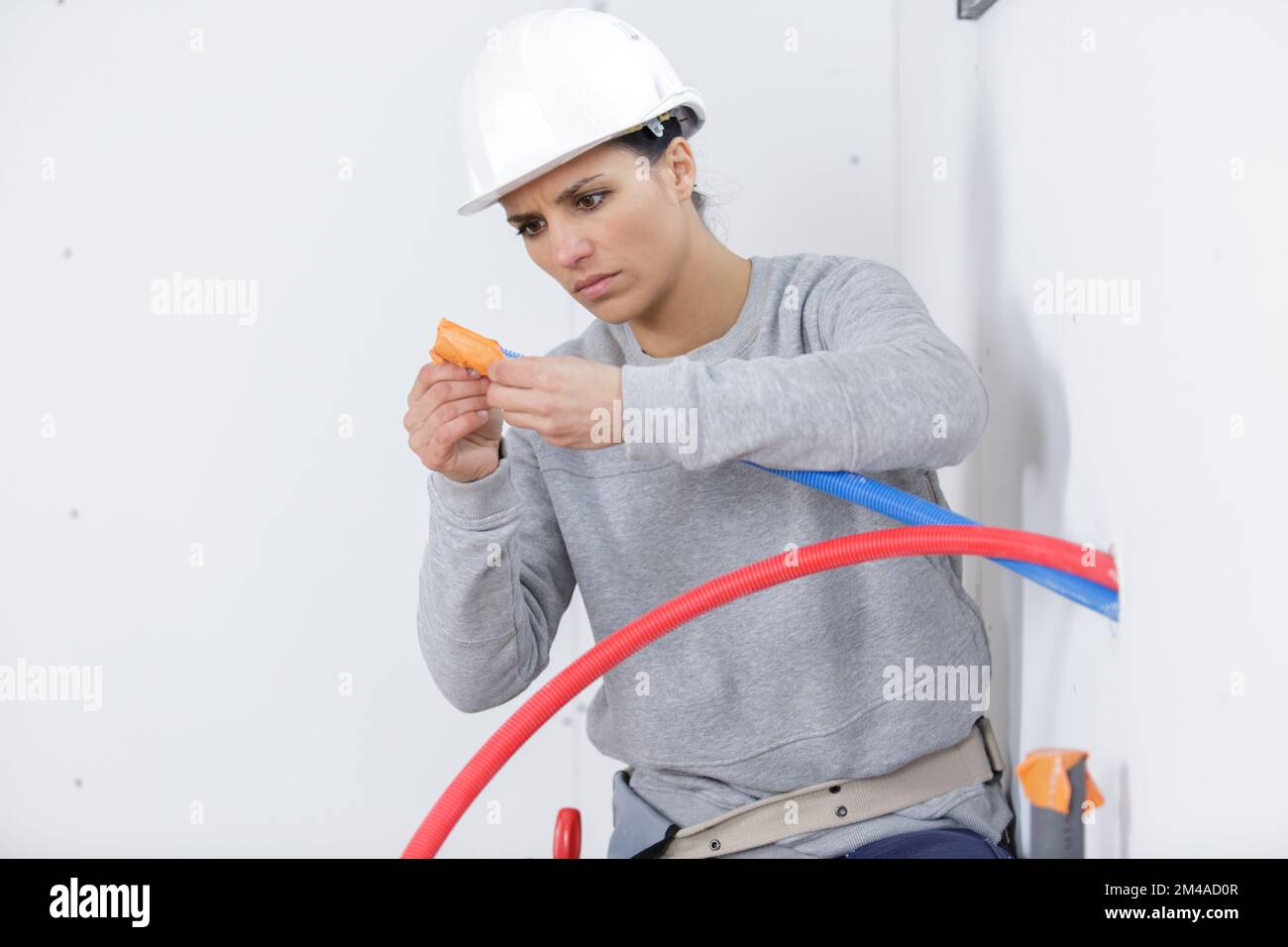female electrician installing a wall socket Stock Photo