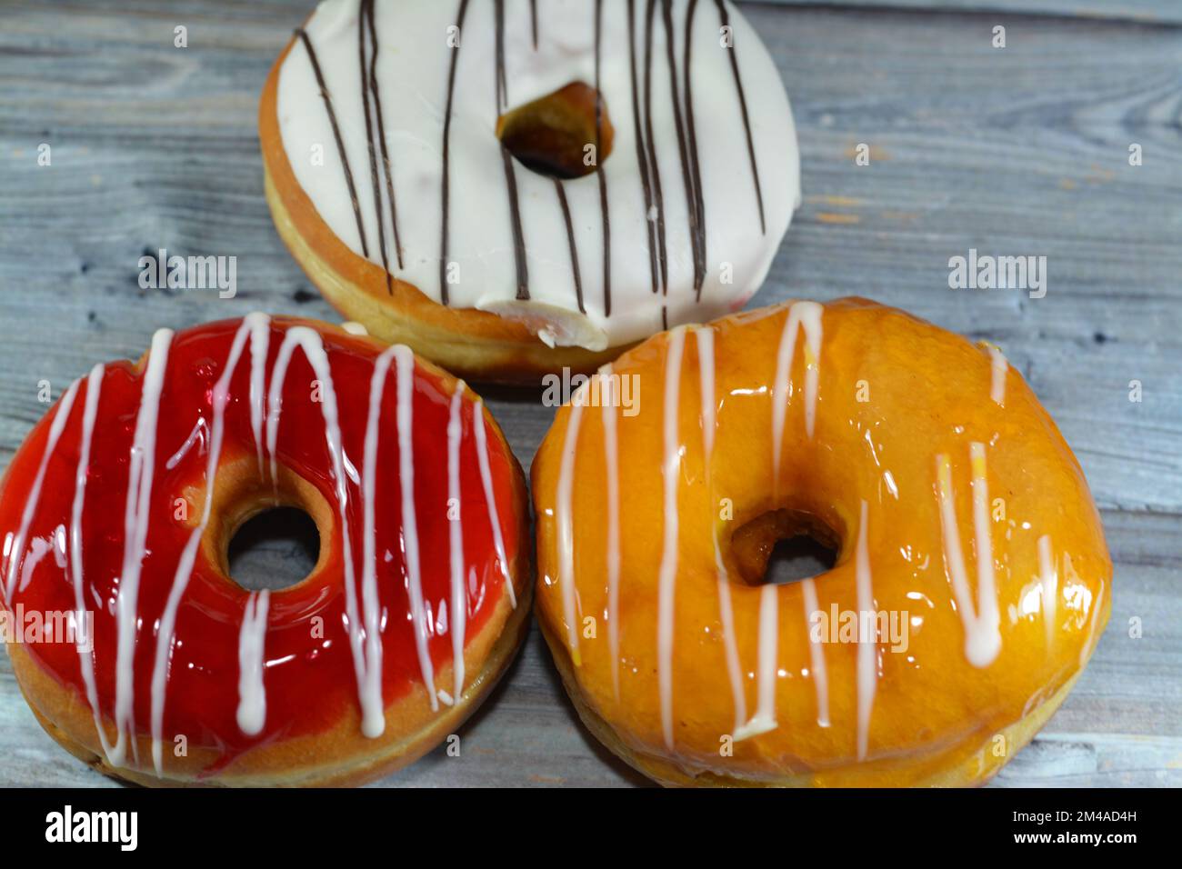 Ring donuts with white chocolate, strawberry and mango layer flavors with white chocolate sauce, A glazed, yeast raised, American style ring doughnuts Stock Photo