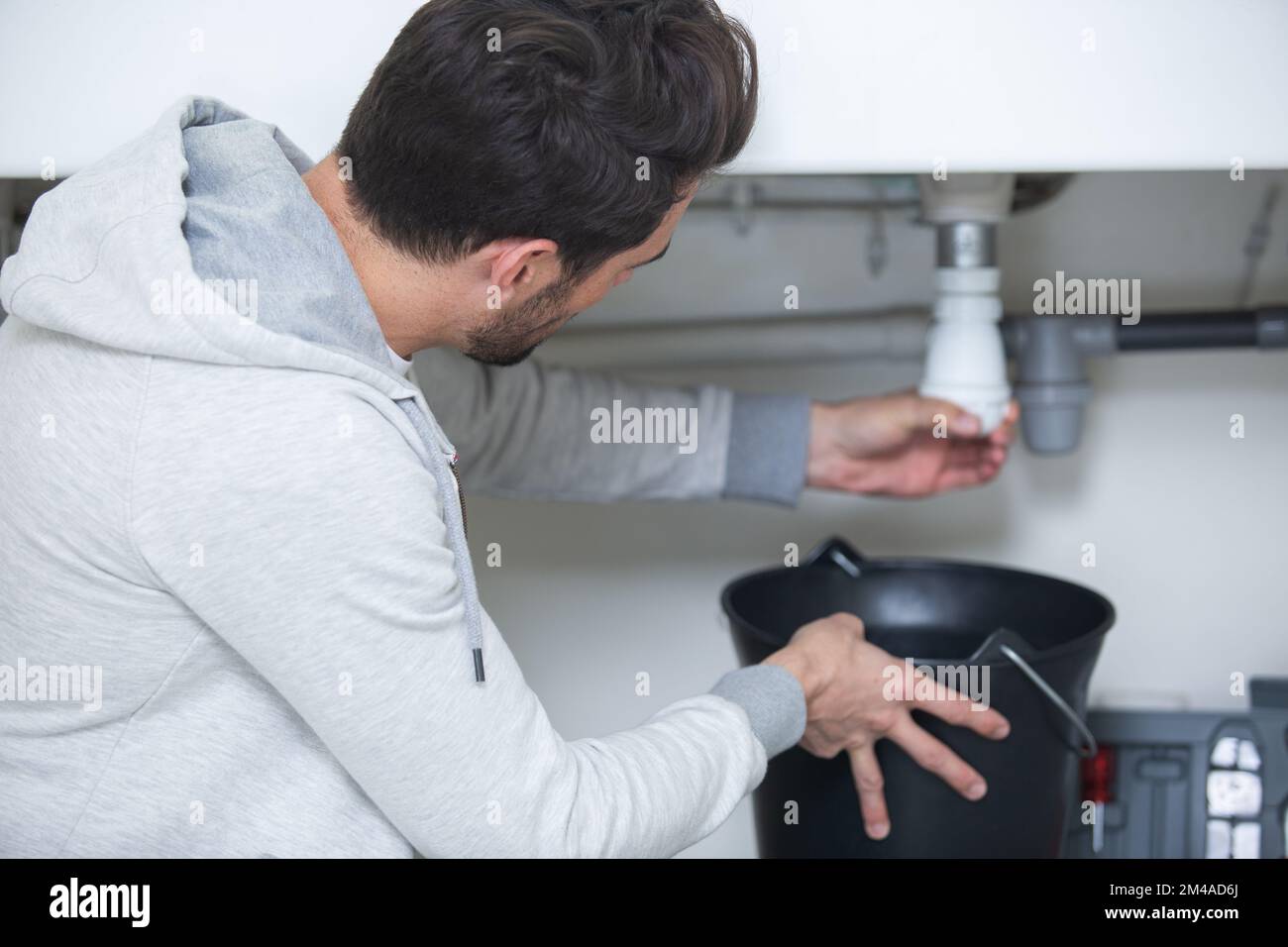 man fixing a leaking pipe under the sink Stock Photo Alamy