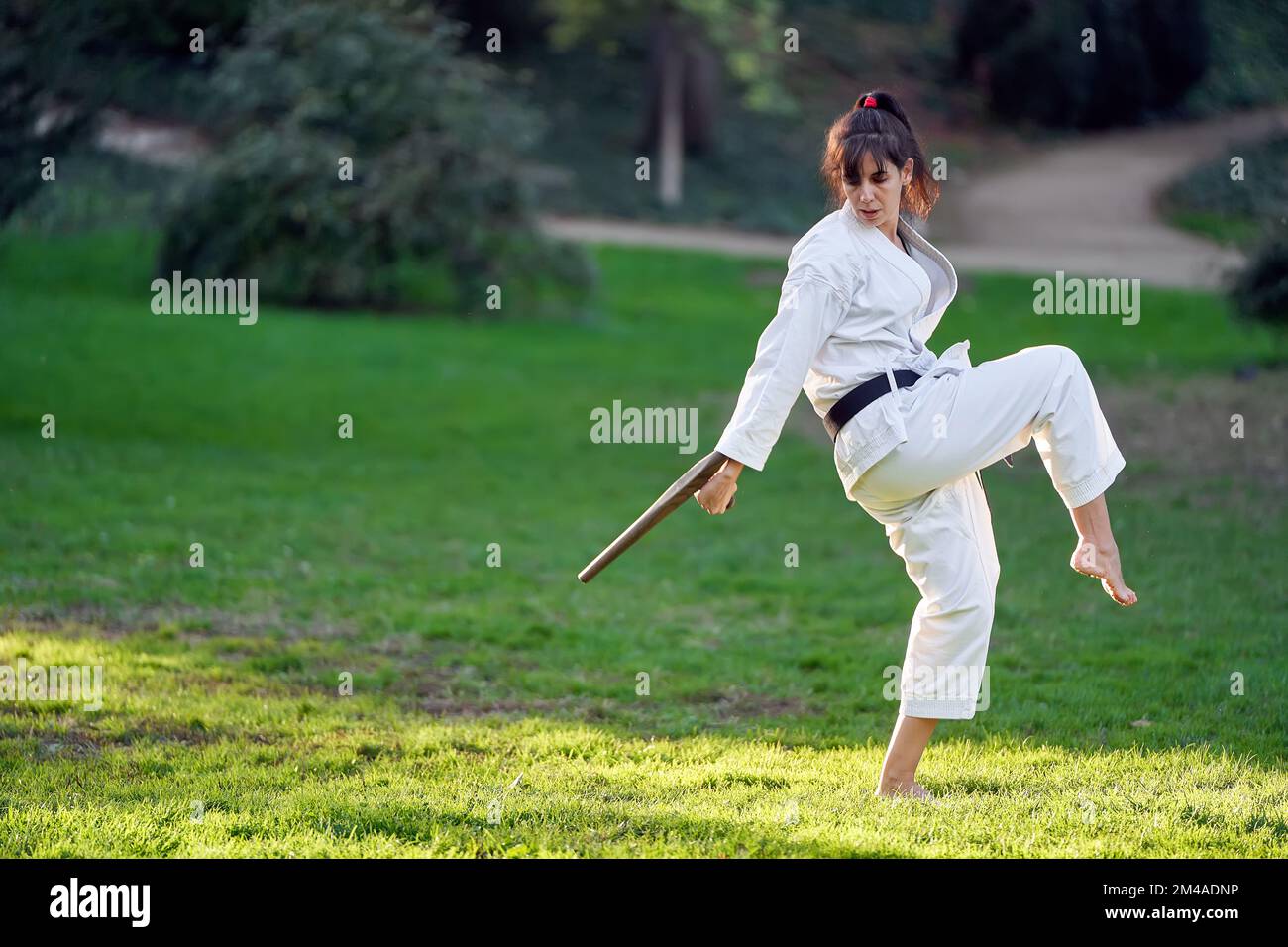 Karate fighter woman in white kimono and black belt practicing karate