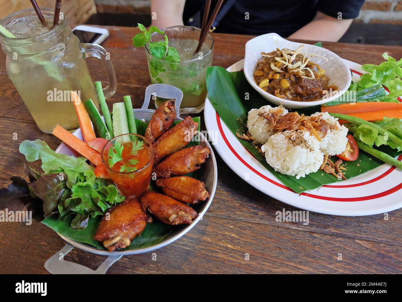 Fried sticky rice served with northern Thai curry, chicken wings and