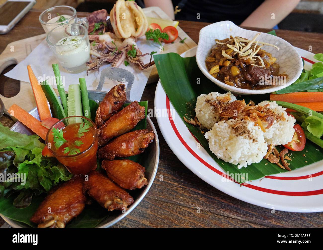 Fried sticky rice served with northern Thai curry, chicken wings and