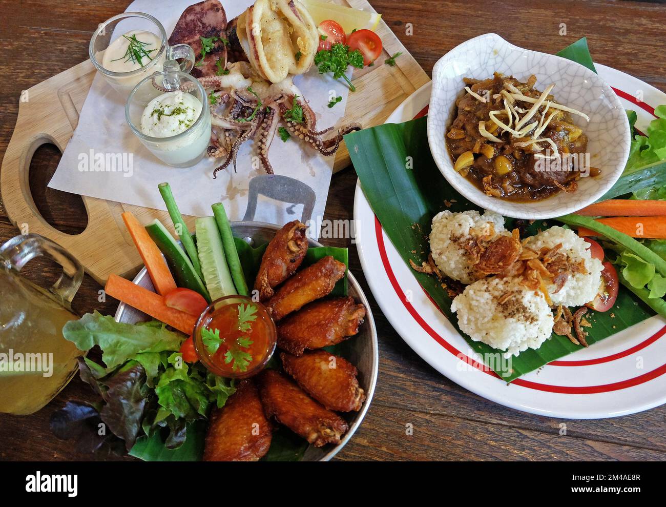 Fried sticky rice served with northern Thai curry, chicken wings and