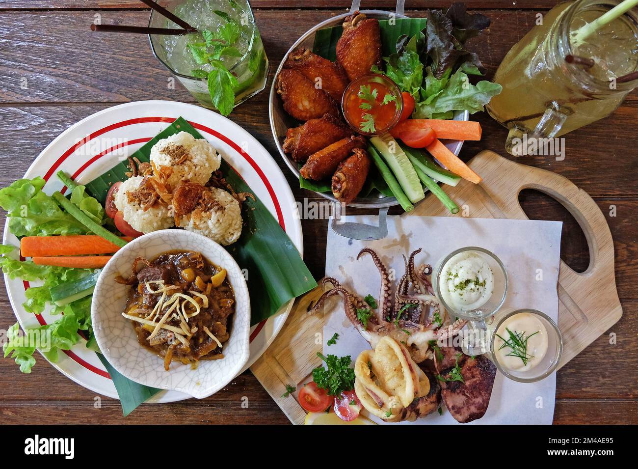 Fried sticky rice served with northern Thai curry, chicken wings and