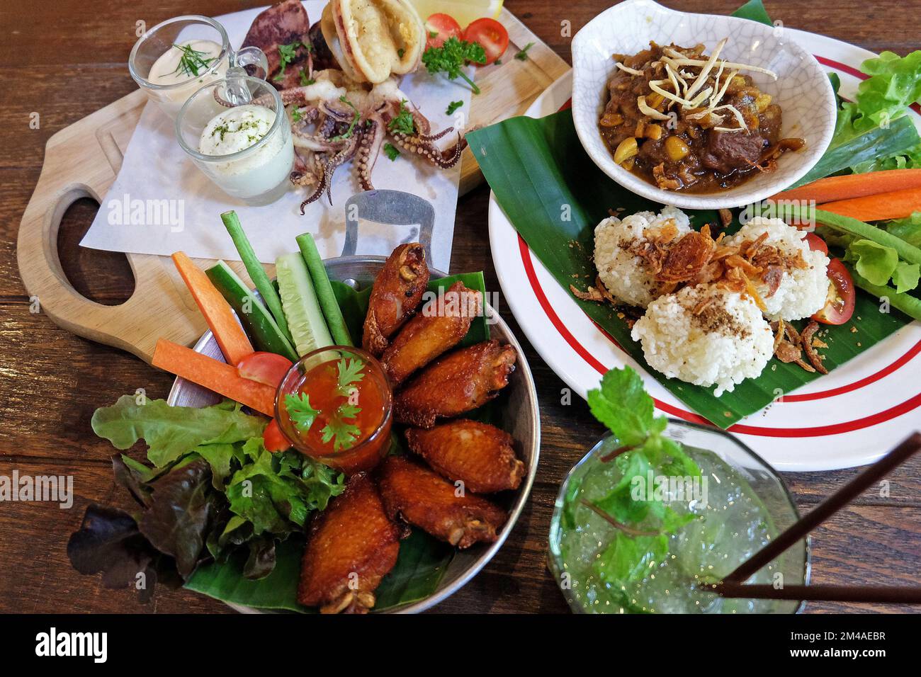 Fried sticky rice served with northern Thai curry, chicken wings and