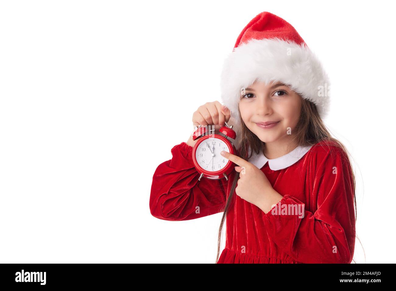 Christmas woman with red alarm clock, smiling girl in red Santa claus dress posing on white background Stock Photo