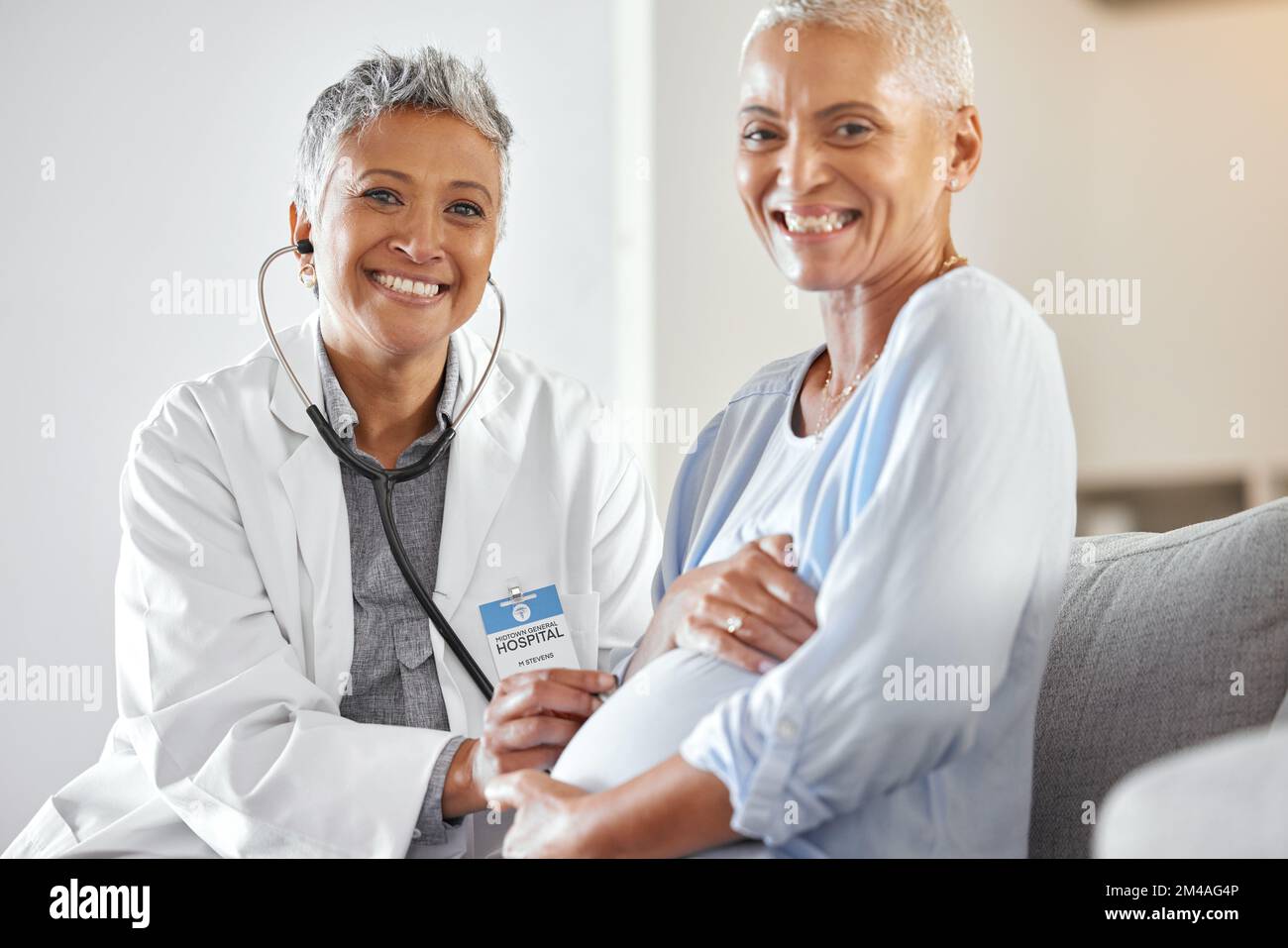 Pregnant, woman and doctor consulting on sofa in a clinic for checkup, health and family planning, happy and excited. Portrait, pregnancy and Stock Photo