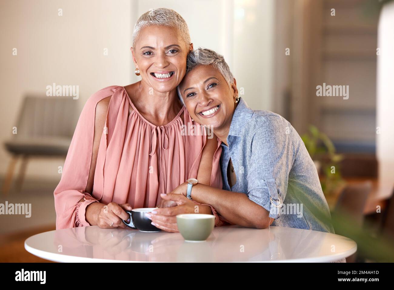Senior women, hug and friends at cafe, having fun and bonding. Portrait, love and retired, happy and elderly females in coffee shop, smiling and Stock Photo