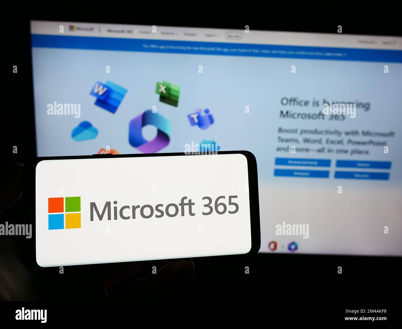 Person holding smartphone with logo of productivity software microsoft