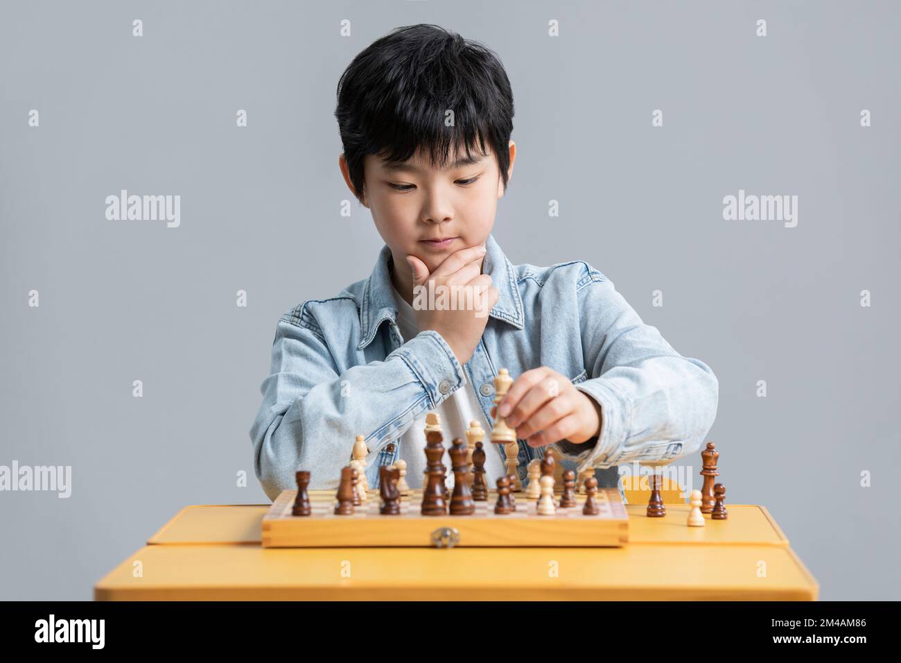 Cute Chinese boy playing chess Stock Photo