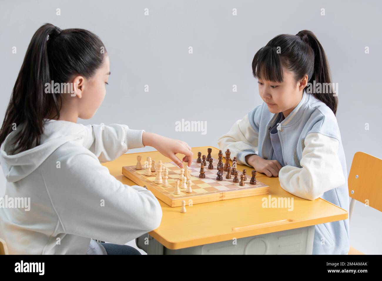 Two Chinese girls playing chess Stock Photo