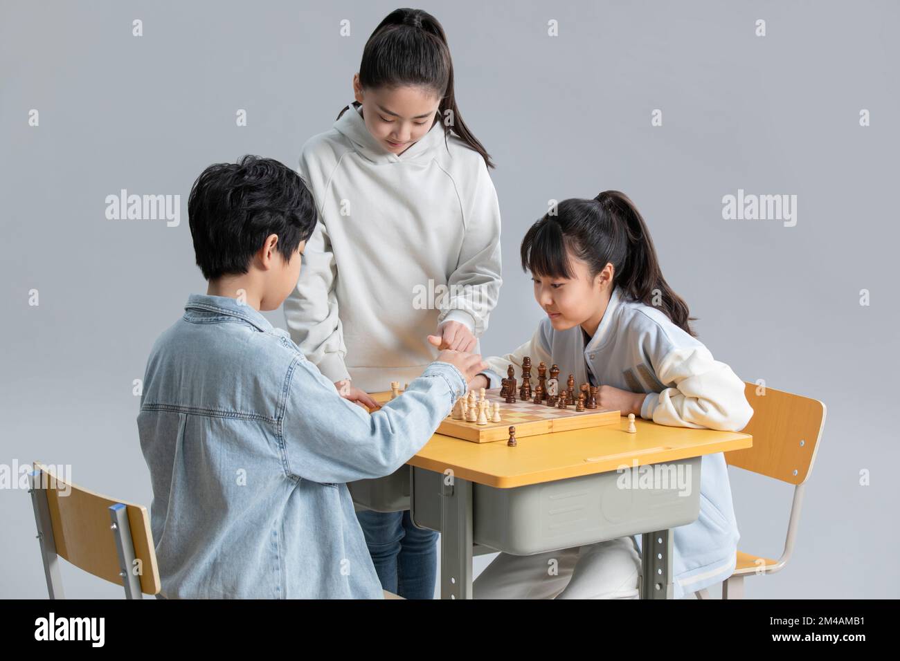 Cheerful Chinese friends playing chess Stock Photo