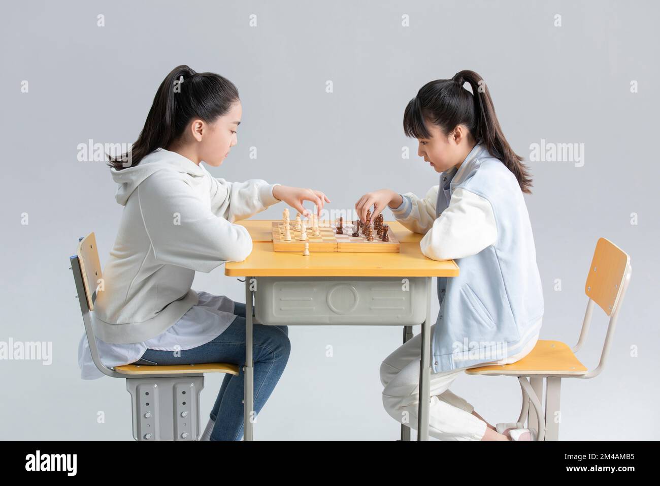 Two Chinese girls playing chess Stock Photo