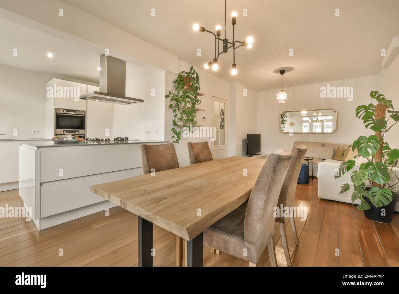 Wooden dining table with chairs placed in modern kitchen with white ...