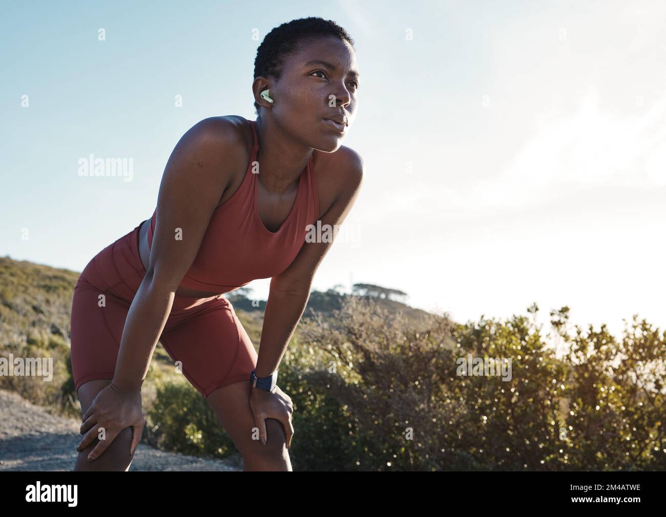 Tired, motivation and black woman running in nature, training exercise and fitness idea in Morocco. Breathing, relax and African runner thinking of a Stock Photo