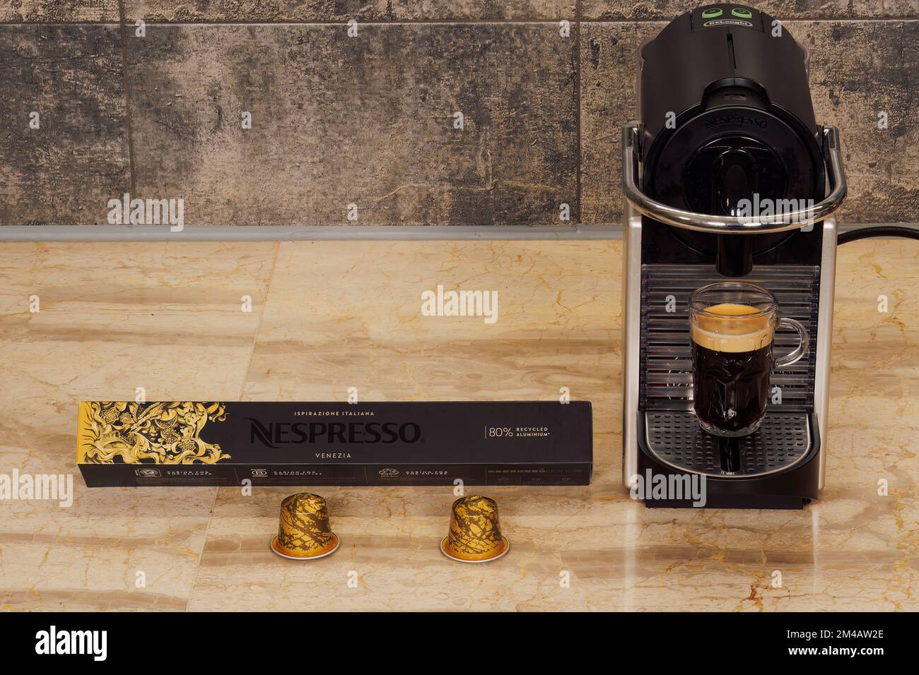 Automatic Nespresso Original machine for espresso with aluminum capsules.  DeLonghi coffeemaker with cup of hot dripping coffee with metal Venezia  pods Stock Photo - Alamy