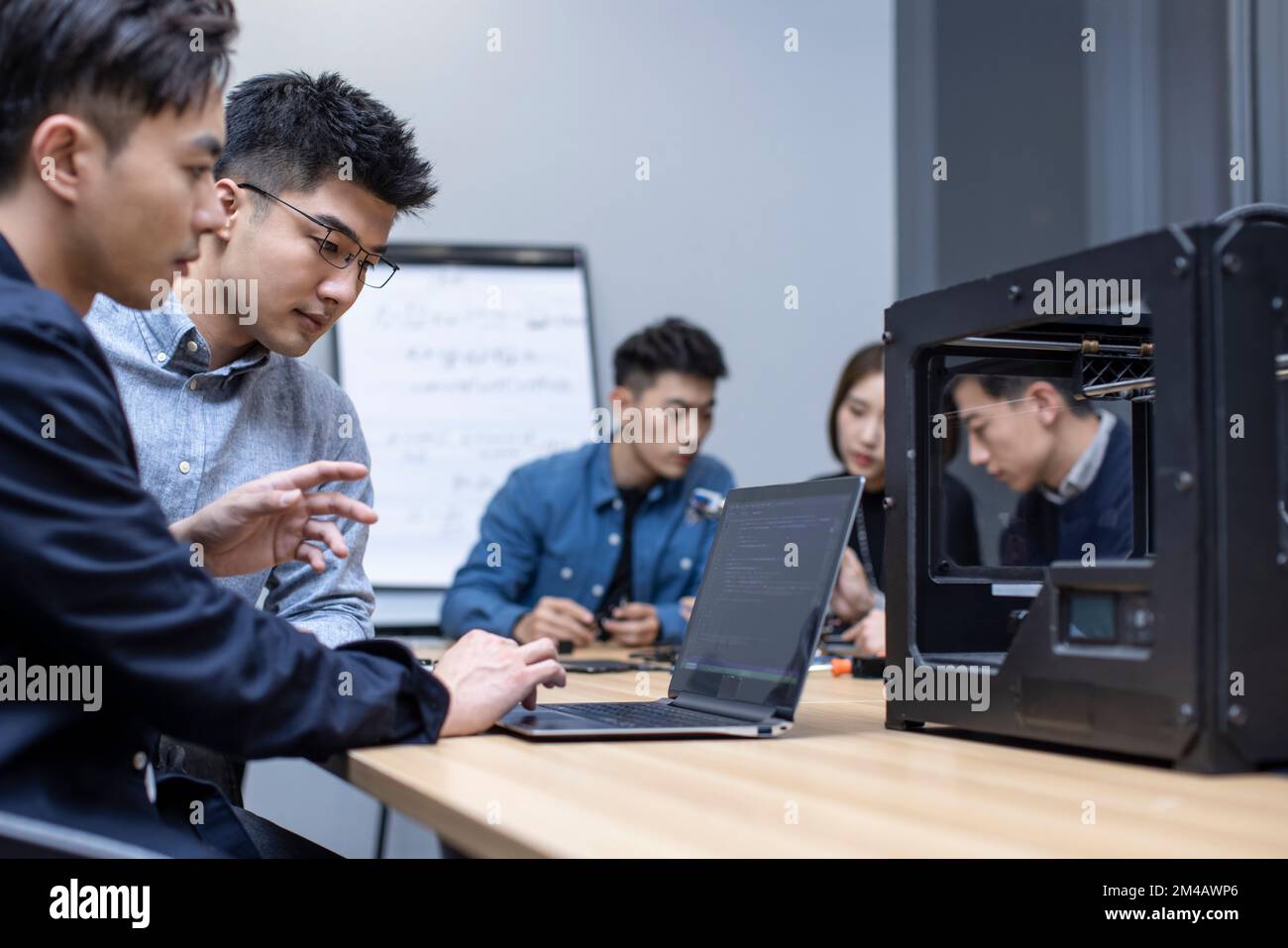 Confident Chinese designers using a 3D printer Stock Photo