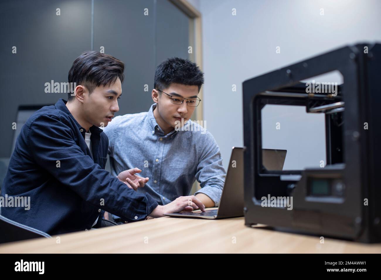 Confident Chinese designers using a 3D printer Stock Photo