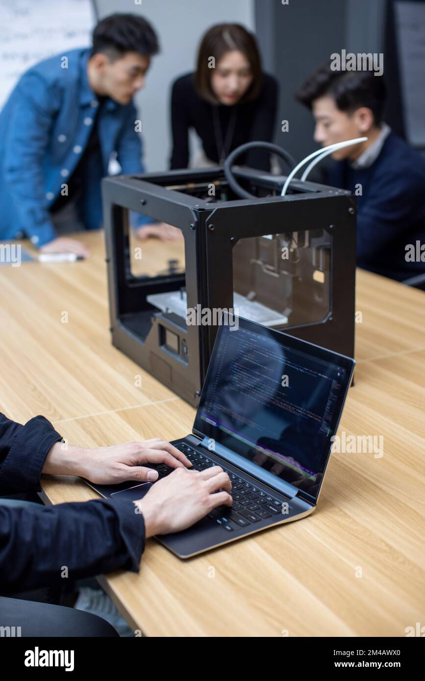 Confident Chinese designers using a 3D printer Stock Photo