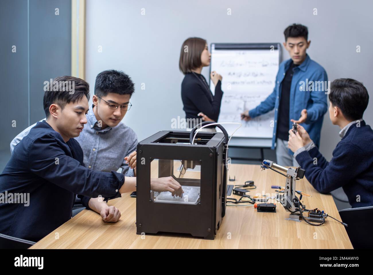 Confident Chinese designers using a 3D printer Stock Photo