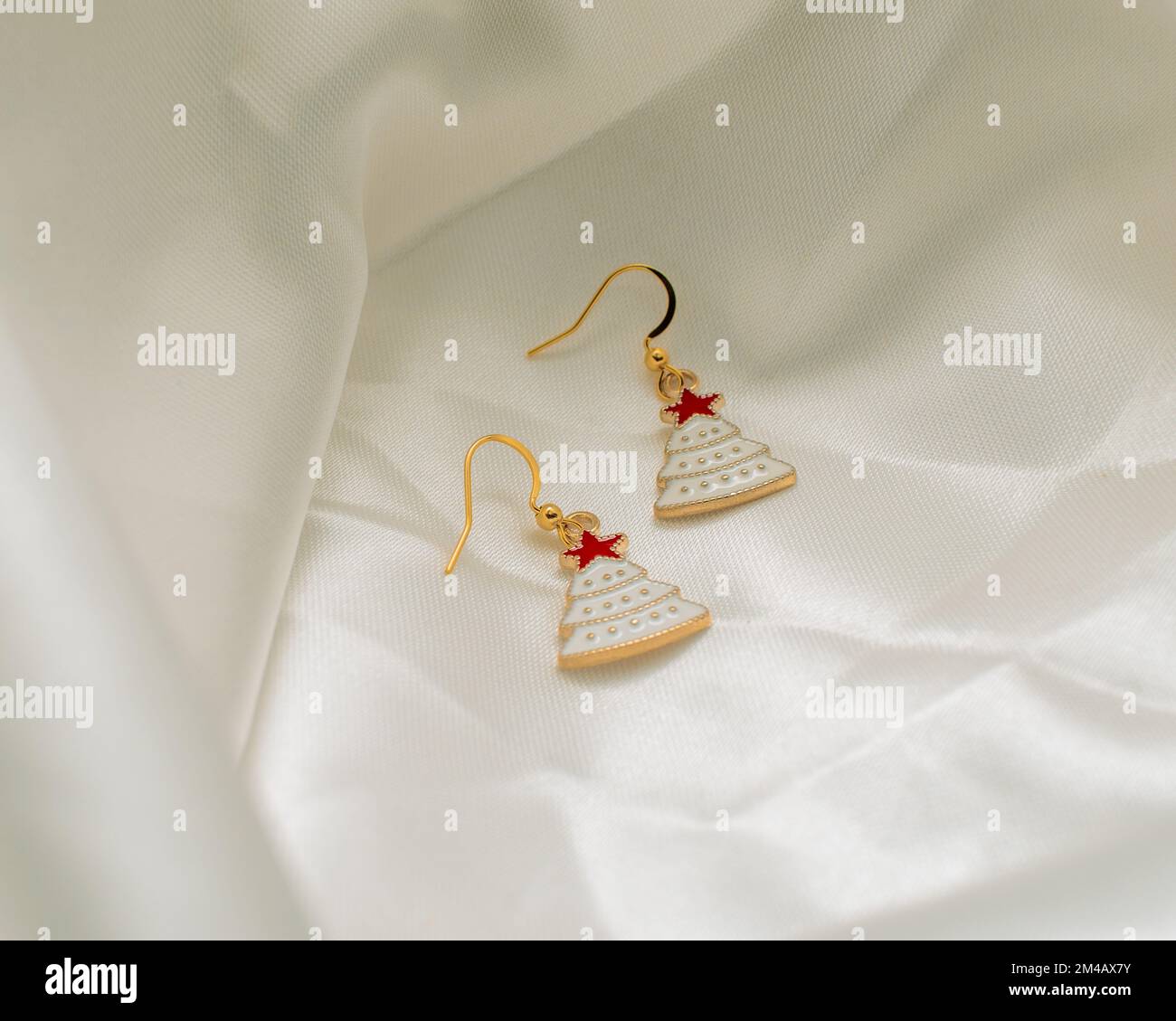 A closeup shot of Christmas tree earrings on a white background Stock Photo
