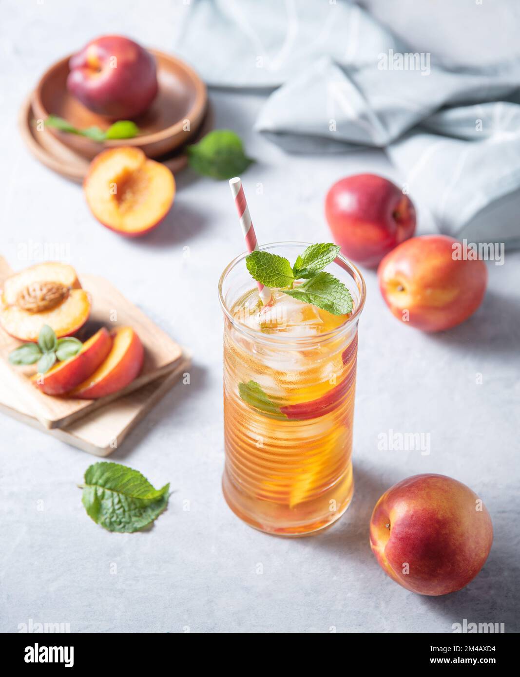 cool peach tea with mint and ice in a glass on a blue background. Top view  and close up image Stock Photo