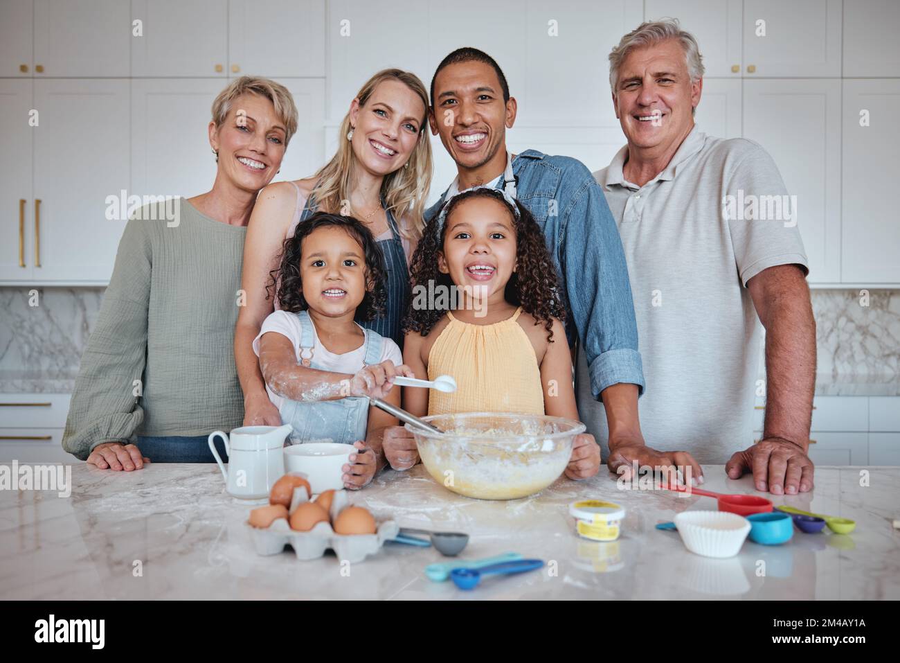 Happy family, learning cooking and portrait in kitchen in family home for love, support and teaching children breakfast recipe. Big family, parents Stock Photo