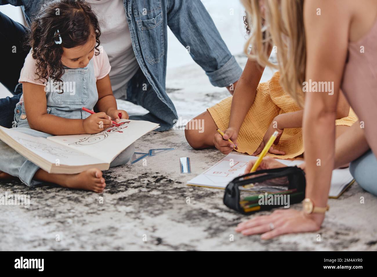 Kids, floor and coloring book with parents for learning, education and fun on family home carpet. Girl children, mom and dad on flooring for teaching Stock Photo
