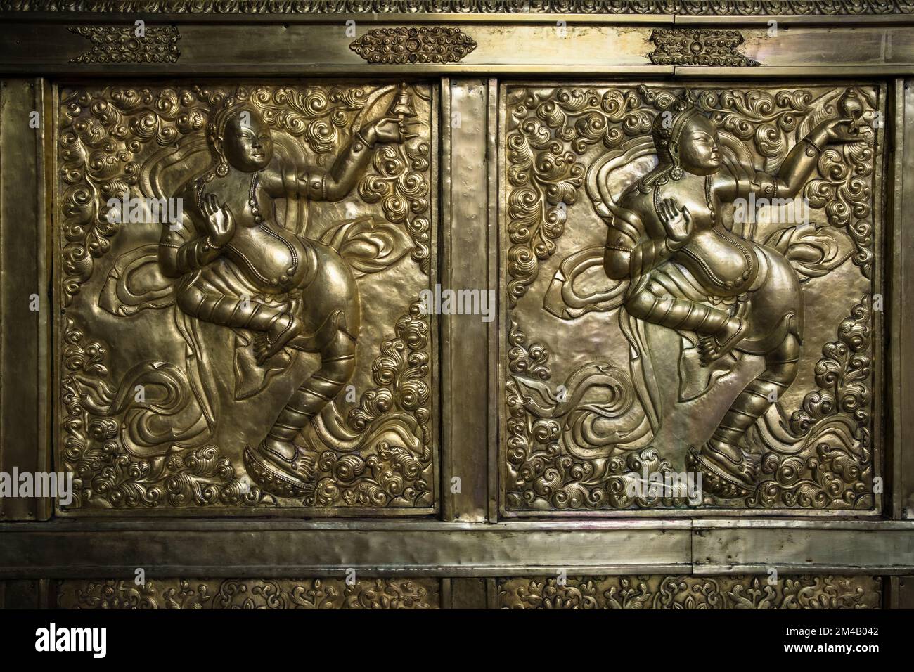 Large embossed gilt copper plaque with figures of dancers inside the Jokhang temple, in Lhasa. Tibet Autonomous Region. China. Stock Photo