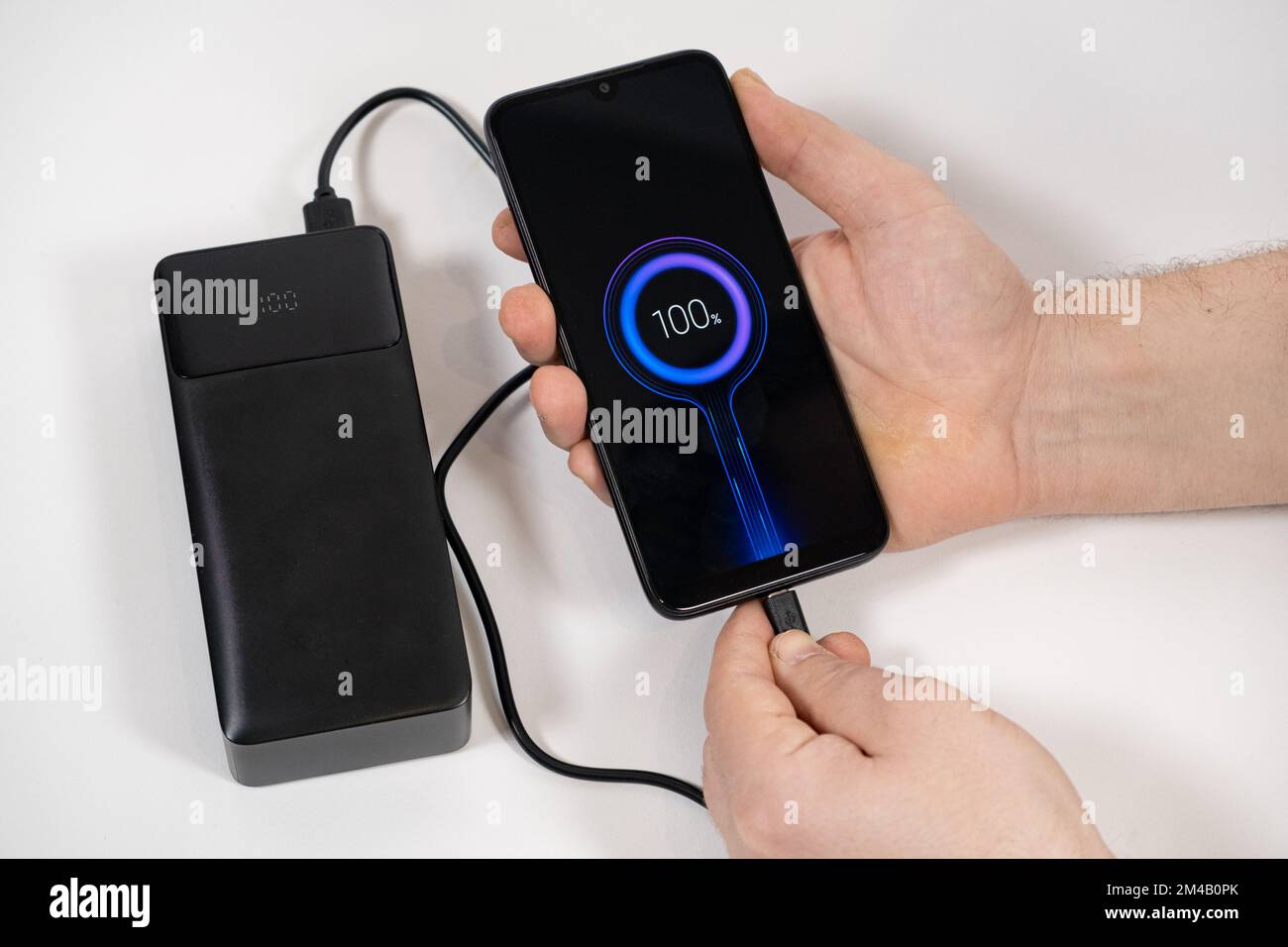 Connecting a mobile phone to a power bank. Charging gadgets from power banks. Stock Photo