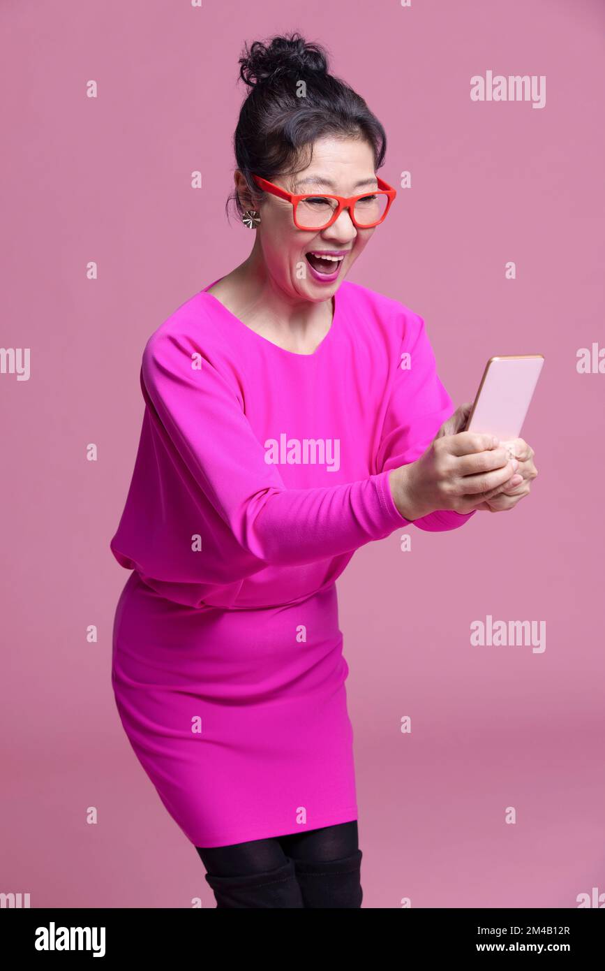 Excited senior woman holding hi-res stock photography and images - Alamy