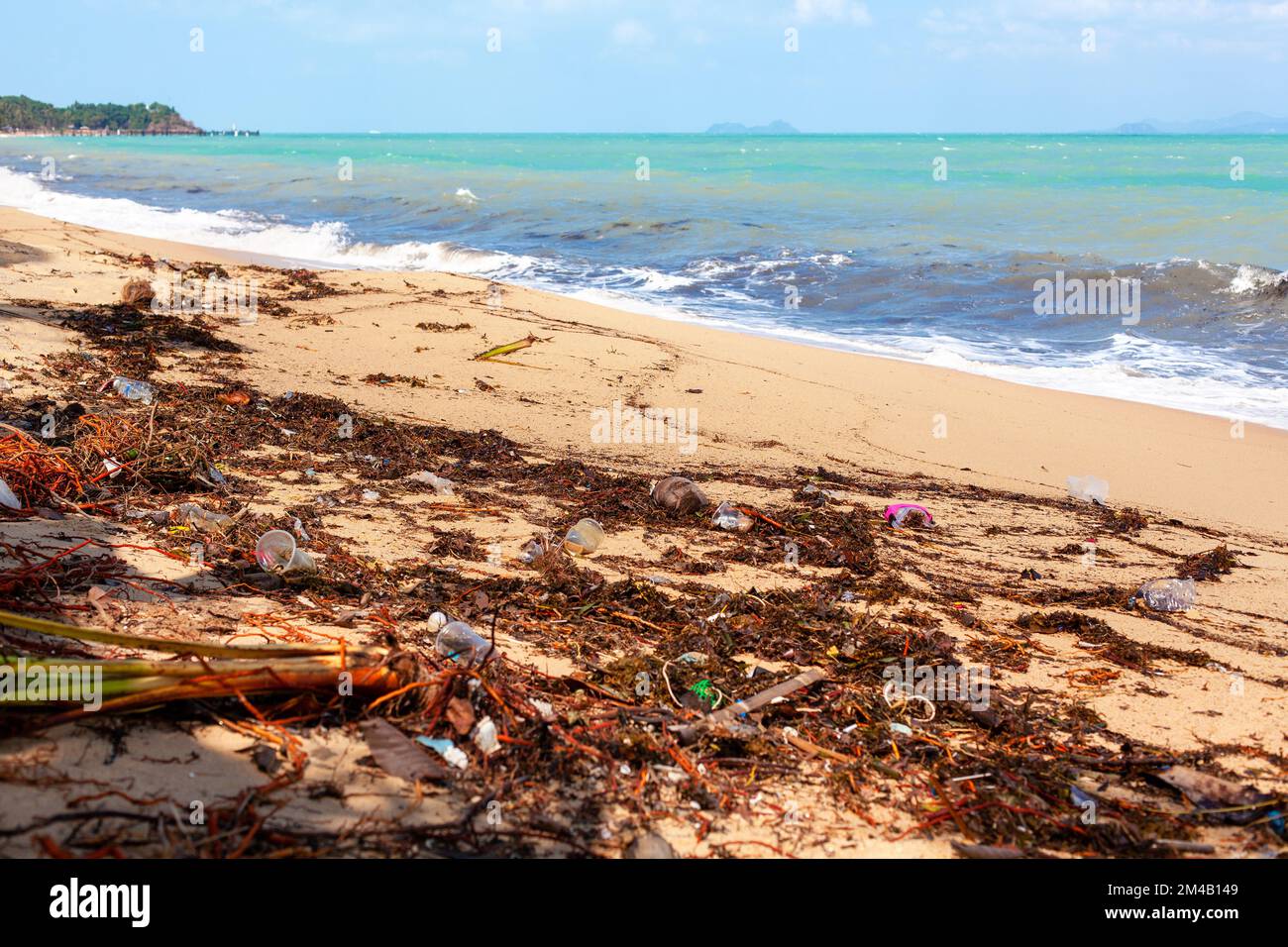Garbage sea sand beach, unsorted rubbish, plastic bag, glass bottle, metal can, trash, refuse pile, litter, dirty ocean water, environmental pollution Stock Photo
