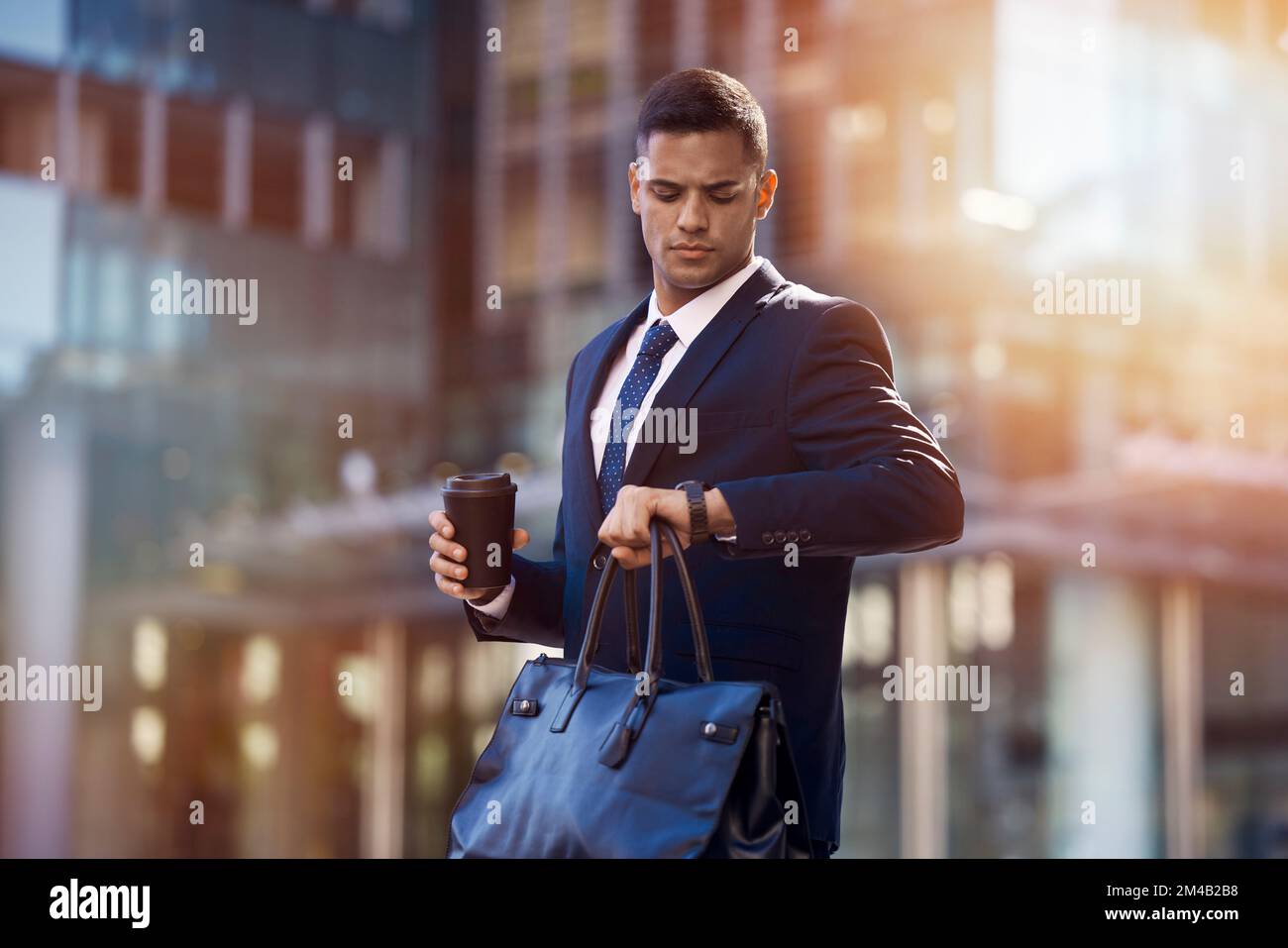 Businessman, city walk and check time for meeting, appointment or transportation with bag, coffee and focus. Young corporate executive, watch clock Stock Photo