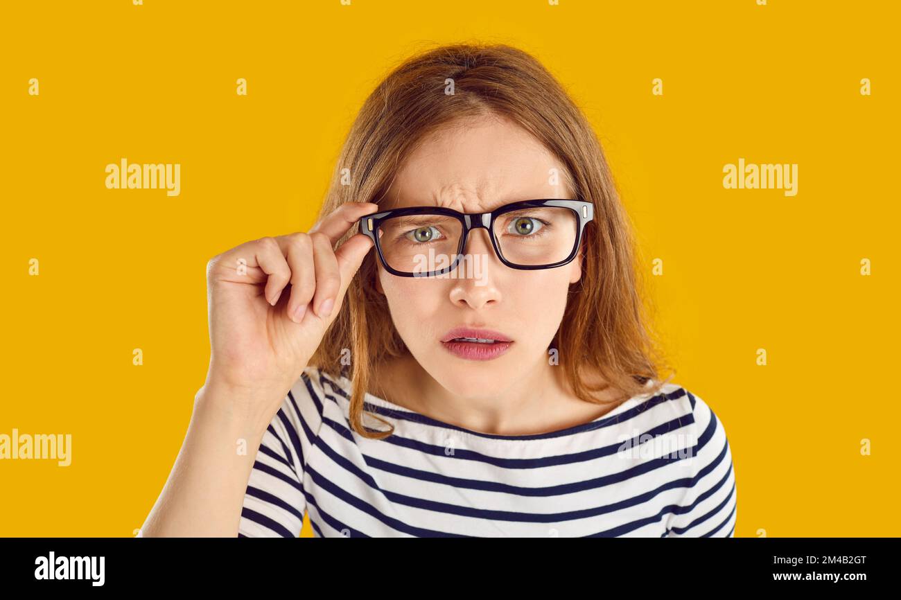 Dissatisfied young woman has focused look and stares at you intently Dissatisfied young woman has focused look and stares at you intently