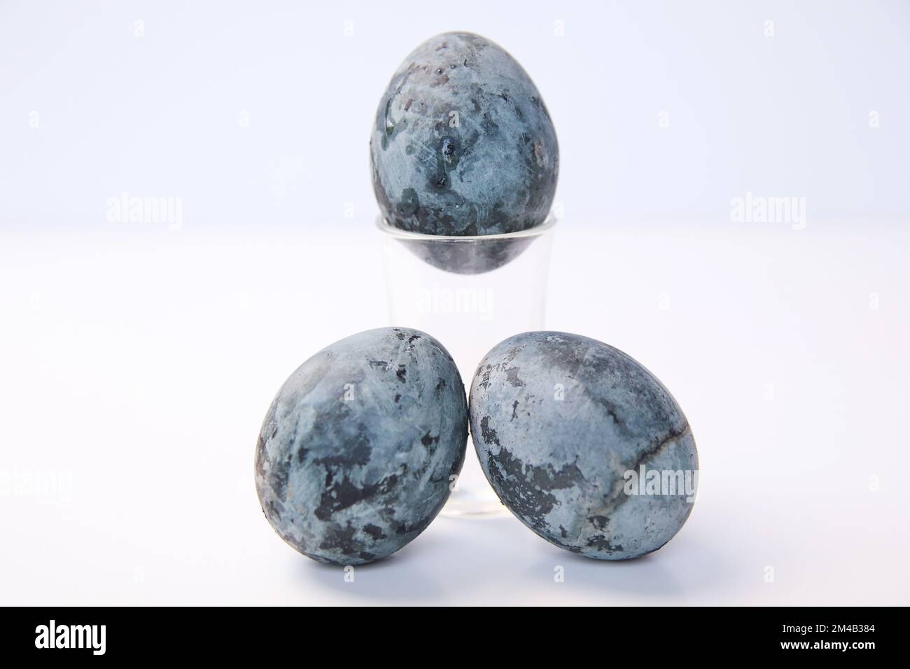 Defocus three blue eggs. Close up Easter egg pastel colored on white background. Minimal Easter celebration concept. Design, art, minimalism. Balance Stock Photo