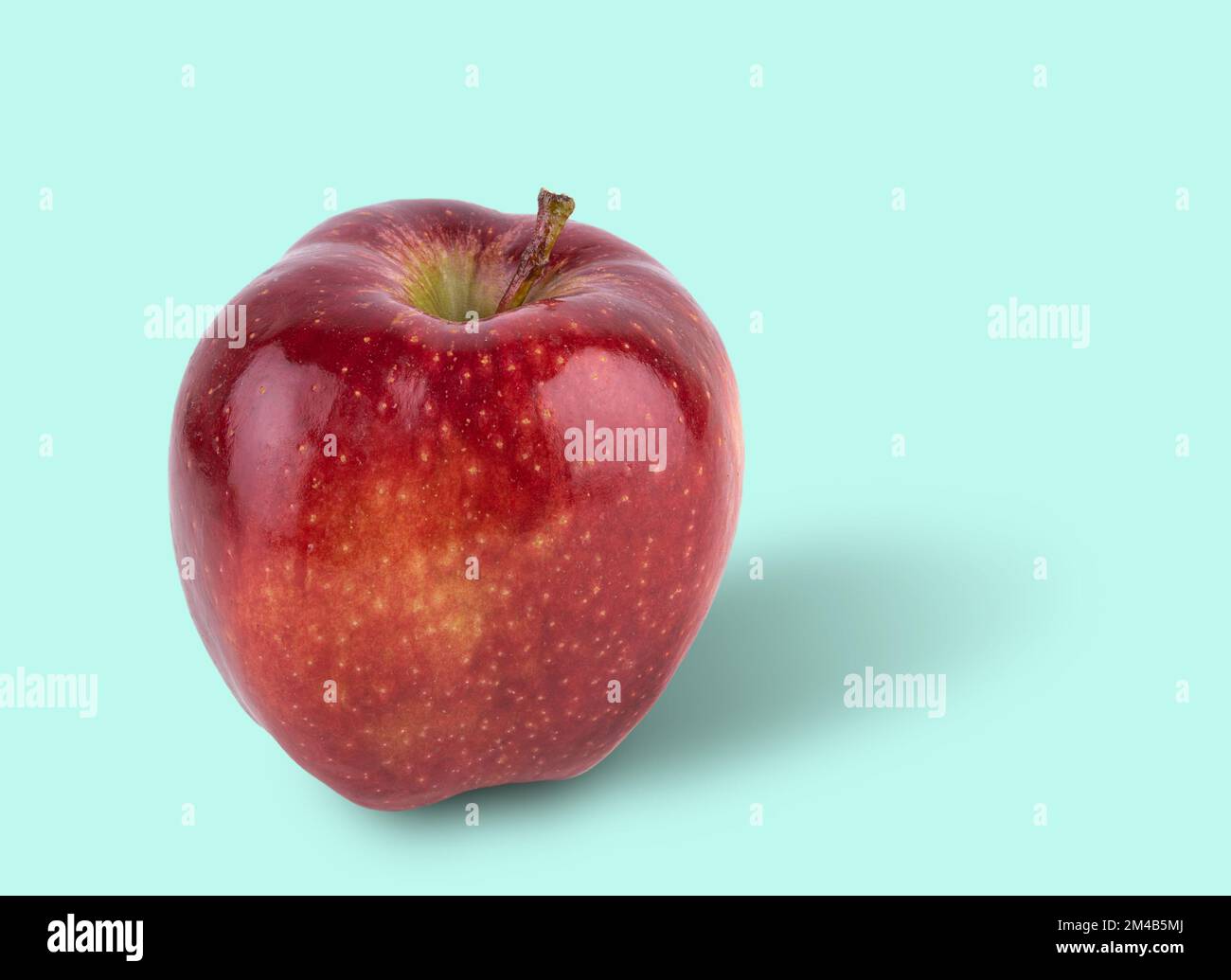 juicy red delicious apple on a light blue background. Front view and copy space. Stock Photo