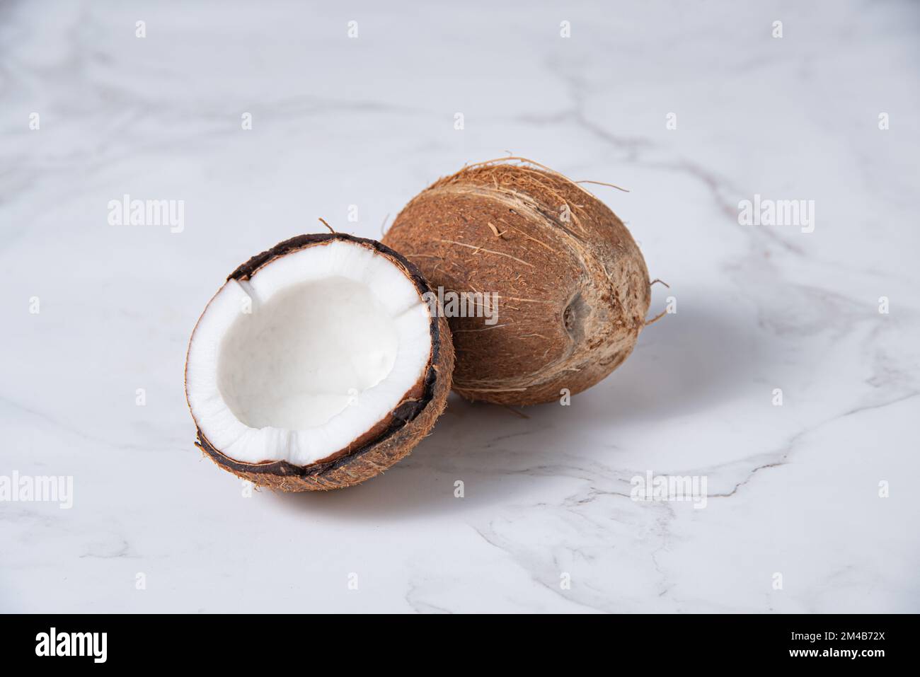 fresh coconut on white marble background. Healthy and vegan food. Copy space image Stock Photo