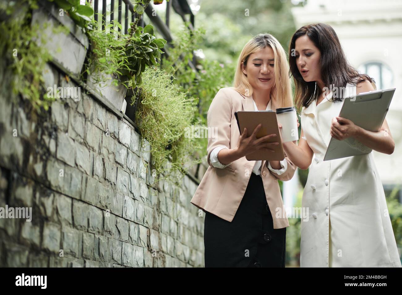 Business colleagues checking details in report on tablet computer Stock Photo