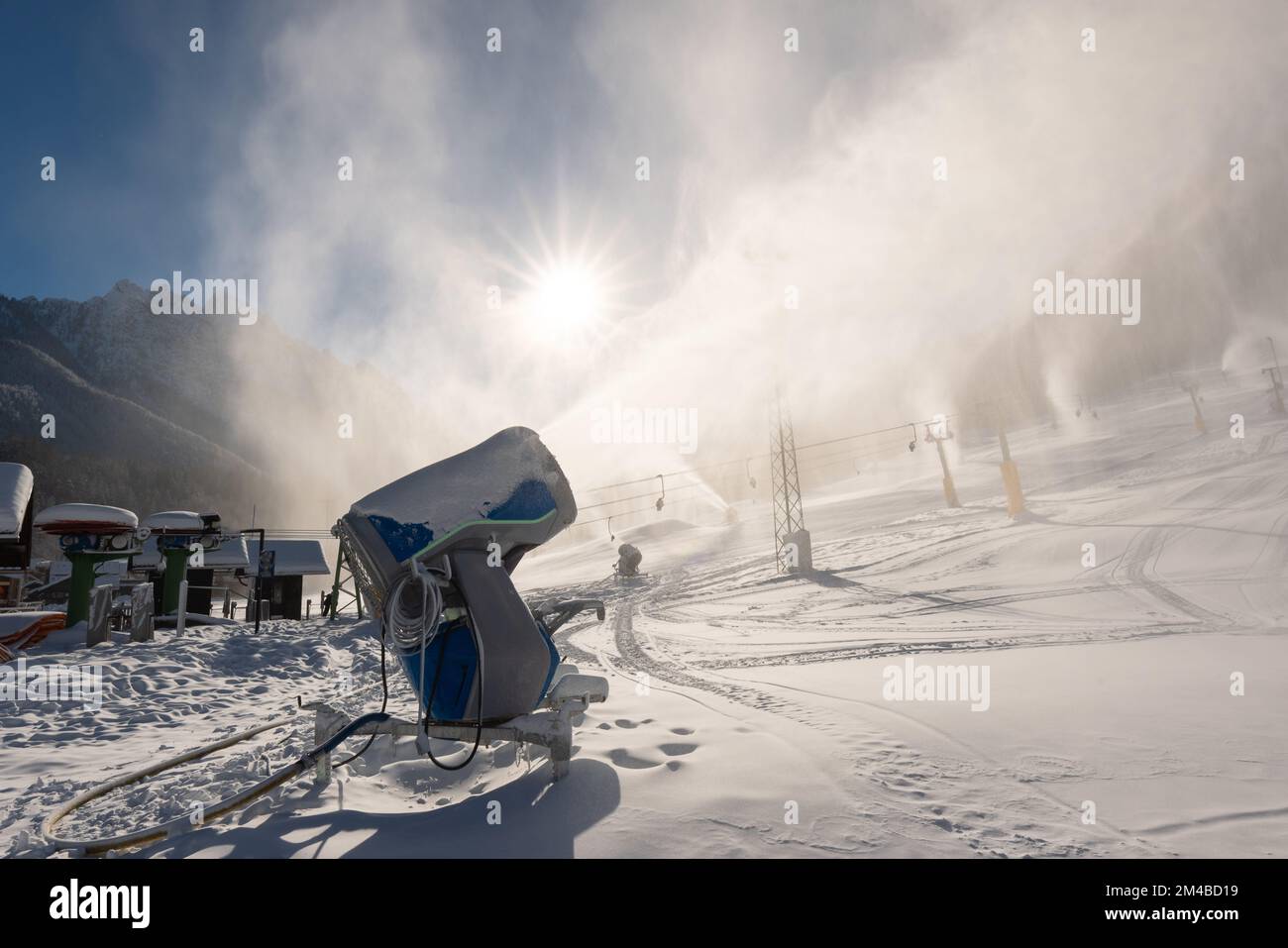 Snowmaking machine snow cannon or gun in action on a cold sunny winter day in ski resort Kranjska Gora, Slovenia Stock Photo