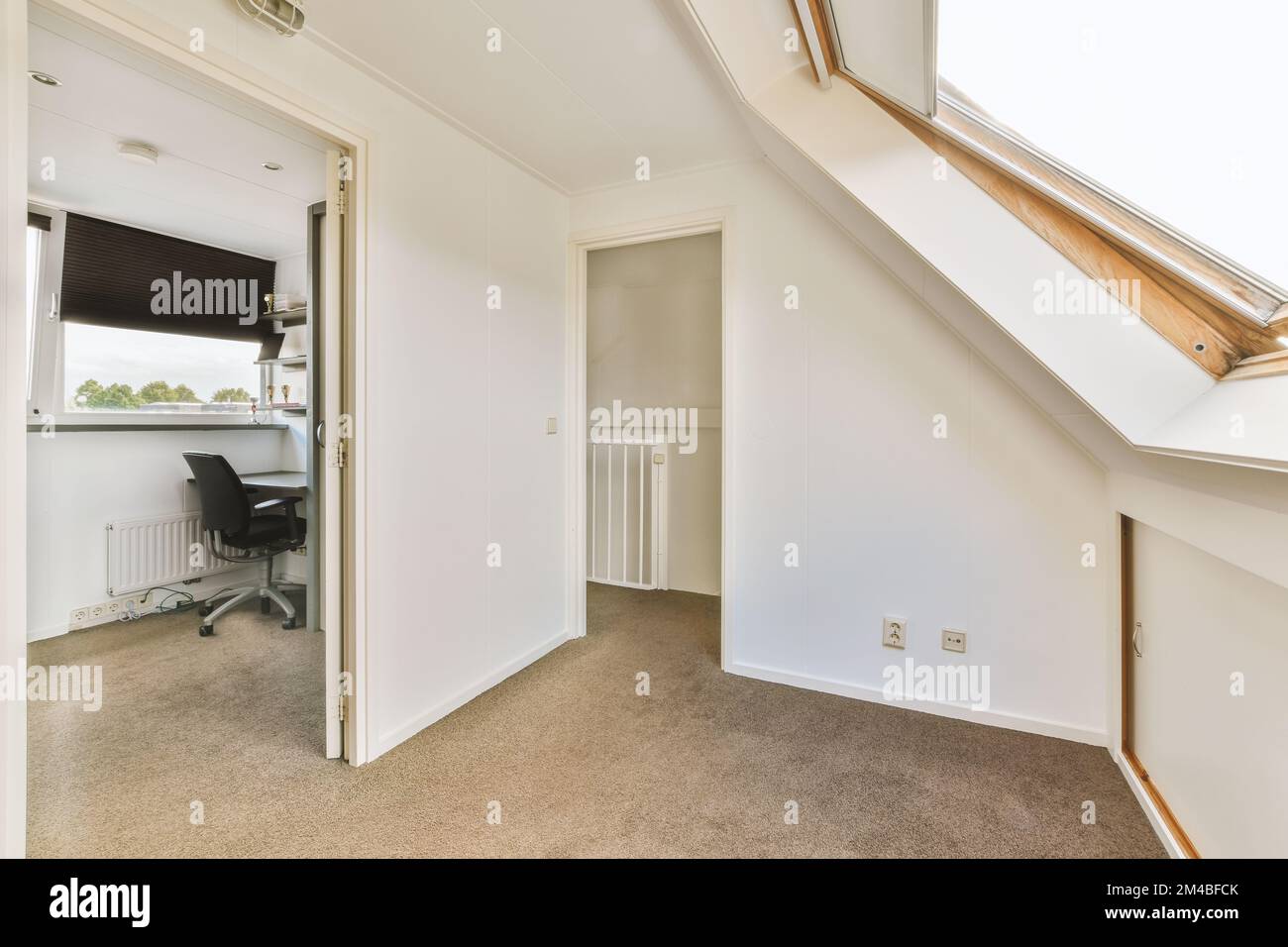 an empty room with a desk and chair in the corner, as seen from the ...