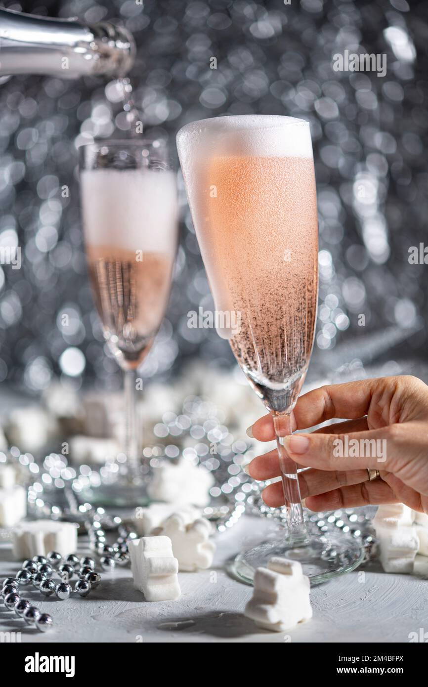 A couple celebrating with sparkling rose wine on grey ornamental background Stock Photo