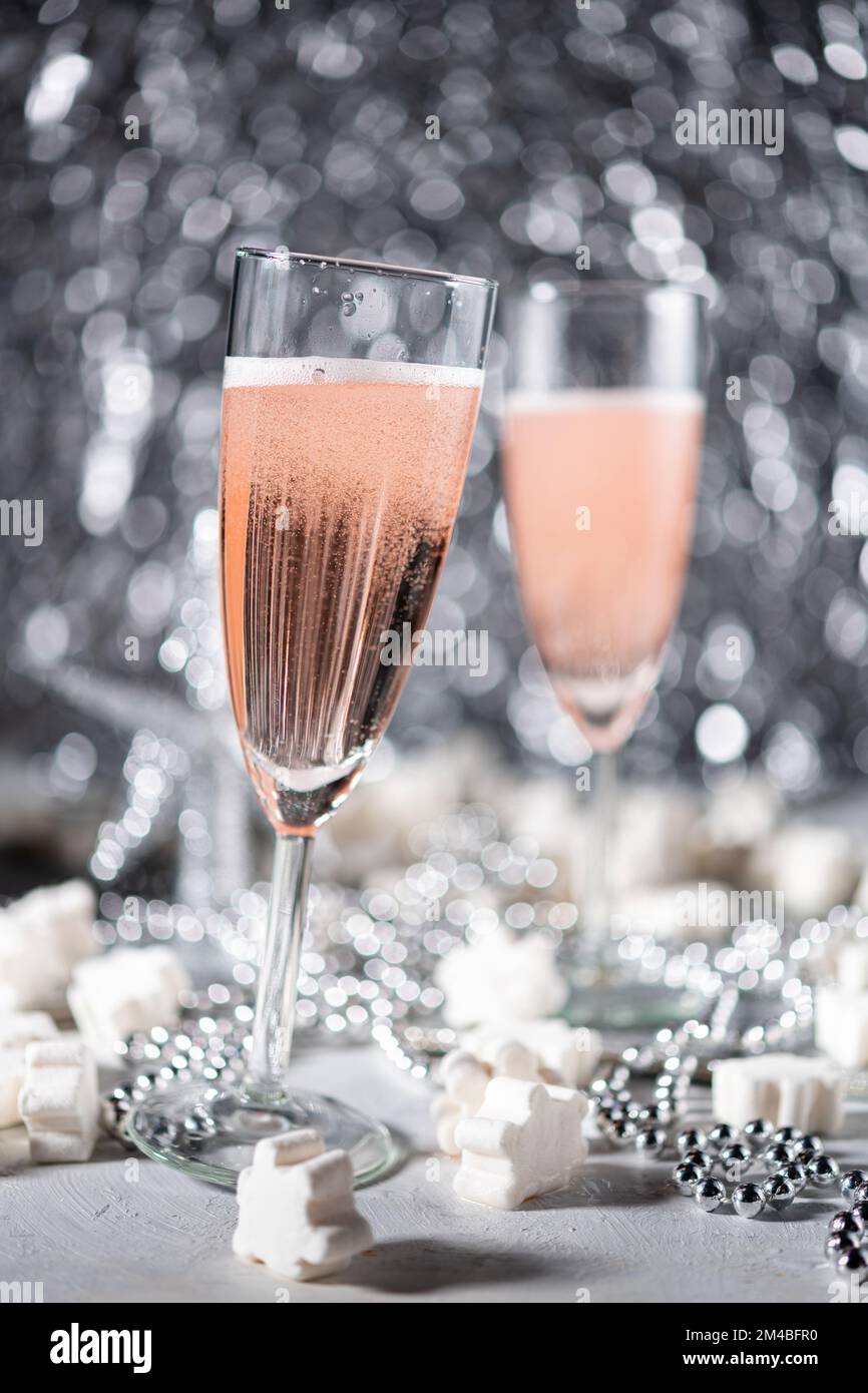 A couple celebrating with sparkling rose wine on grey ornamental background Stock Photo