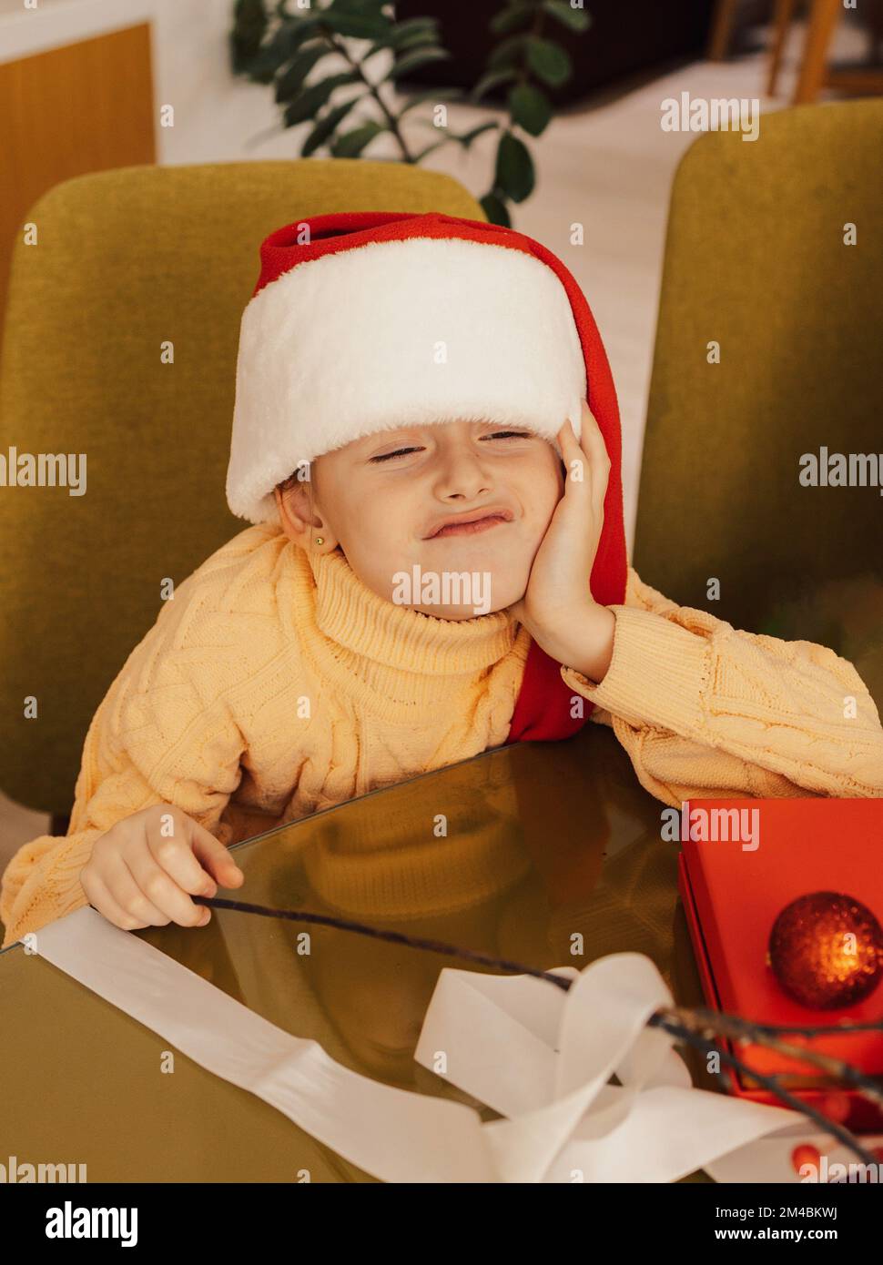 funny baby girl in Santa hat is waiting for Christmas gifts Laughing and having fun. Merry Christmas. Stock Photo
