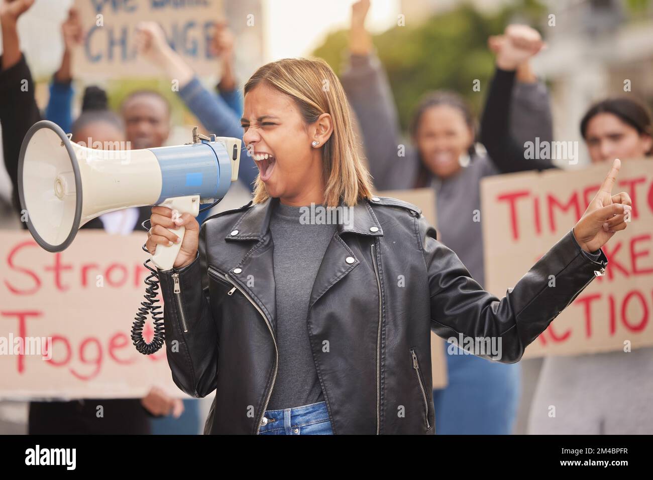Protest, demonstration and woman with megaphone in city shouting for justice, freedom and equality. Free speech, human rights and crowd of people Stock Photo