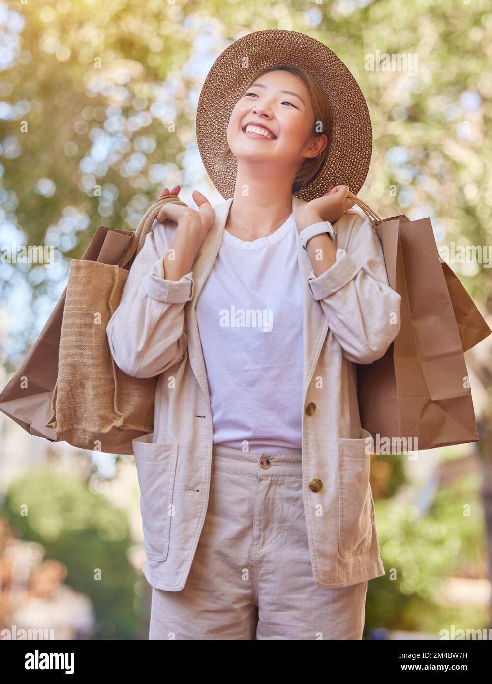Grocery shopping, happy and woman in the city for groceries, thinking of sale and food discount in Singapore. Retail smile, shopping bag and Asian Stock Photo