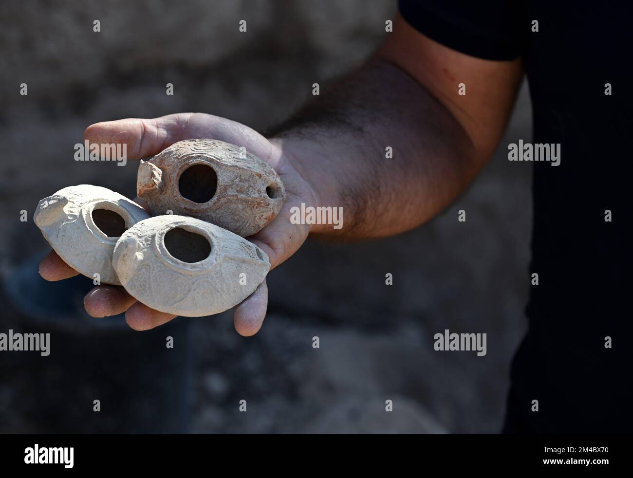 An archeologist from The Israel Antiquities Authority holds clay lamps from the eighth and ninth centuries CE, unearthed in the courtyard of an elaborate 2,000 year old Second Temple Period family burial cave, known as the Salome Cave, in the Lachish Forest in the Judean lowlands, on Tuesday, December 20, 2022. Archeologists say the cave was continued to be used in the Byzantine and Early Islamic Periods and became known as the Salome Cave due to the tradition that believes it is the burial place of Salome, the midwife of Jesus. Photo by Debbie Hill/ UPI Stock Photo